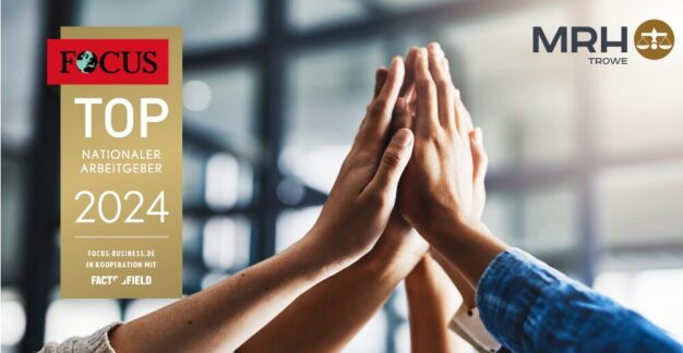 Team von Kollegen gibt ein High-Five in einem hell beleuchteten Büro, wobei im Vordergrund eine Auszeichnung mit der Aufschrift 'FOCUS TOP Nationaler Arbeitgeber 2024' zu sehen ist. Kooperation mit focus-business.de und fact_field.