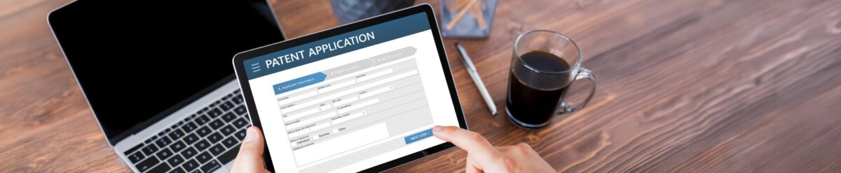 Person hält ein Tablet mit geöffneter Online-Patentanmeldung, Symbol für Schutz von Erfindungen und Patenten.