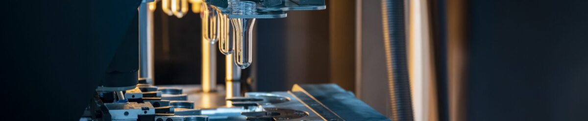 Maschinelle Herstellung von Kunststoffteilen in einer Produktionsanlage, Symbol für Produktsicherheit und die Absicherung durch eine Produktschutzversicherung.