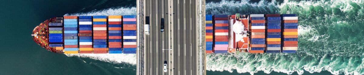 Containerschiff von oben mit bunten Containern auf dem Meer – Symbolbild für weltweite Transportversicherung und Logistikabsicherung.