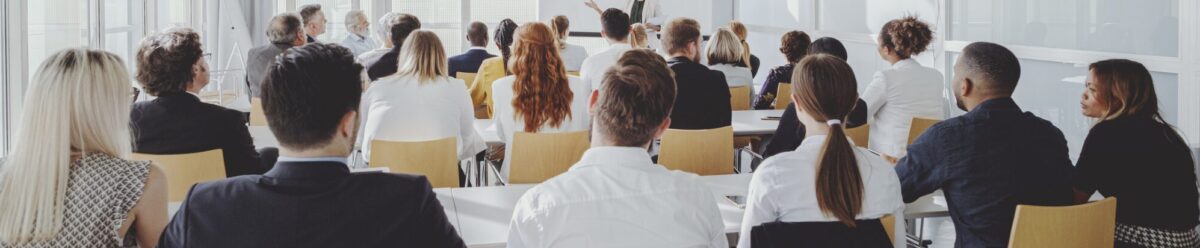 Gruppe von Menschen in einem Seminarraum, Symbol für Veranstaltungen, Events und die Absicherung durch eine Veranstalterhaftpflichtversicherung.
