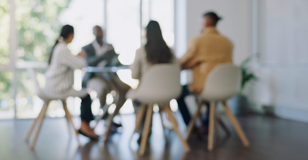 Gruppe von Menschen in einem modernen Büro bei einer Besprechung – Symbolbild für Anstellungsvertrags-Rechtsschutzversicherung und arbeitsrechtliche Absicherung.