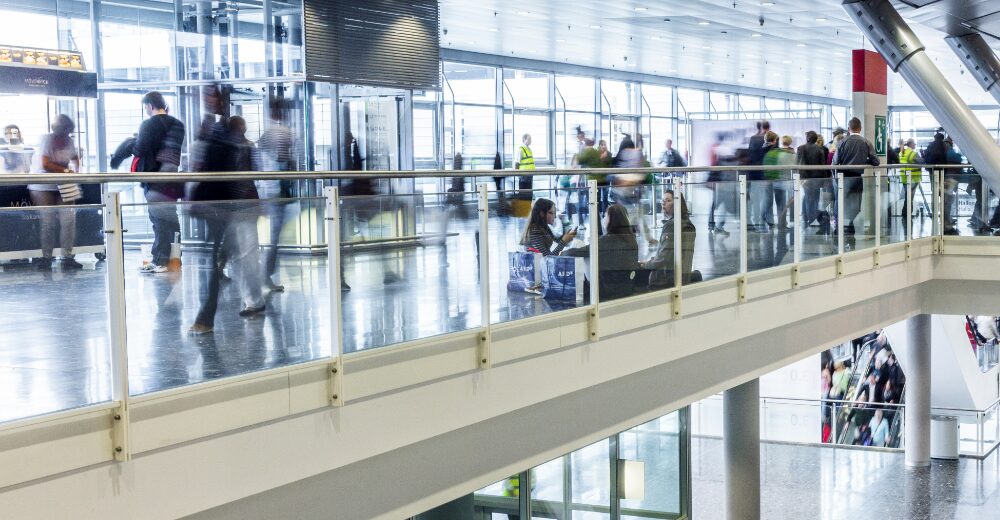 Menschen bewegen sich durch eine Messe- oder Ausstellungshalle – Symbolbild für Ausstellungsversicherung und Veranstaltungsschutz.