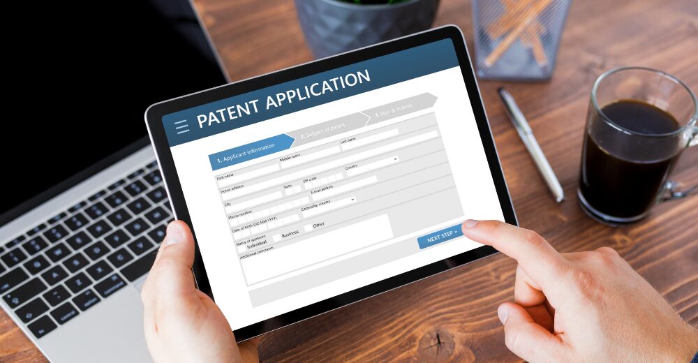 Person hält ein Tablet mit geöffneter Online-Patent­anmeldung, Symbol für Schutz von Erfindungen und Patenten.