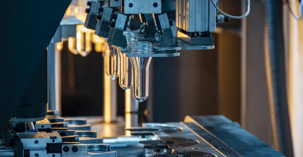 Maschinelle Herstellung von Kunststoffteilen in einer Produktionsanlage, Symbol für Produktsicherheit und die Absicherung durch eine Produktschutzversicherung.