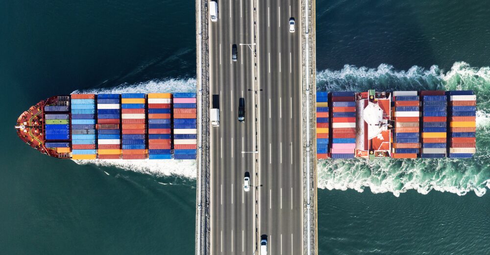 Containerschiff von oben mit bunten Containern auf dem Meer – Symbolbild für weltweite Transportversicherung und Logistikabsicherung.