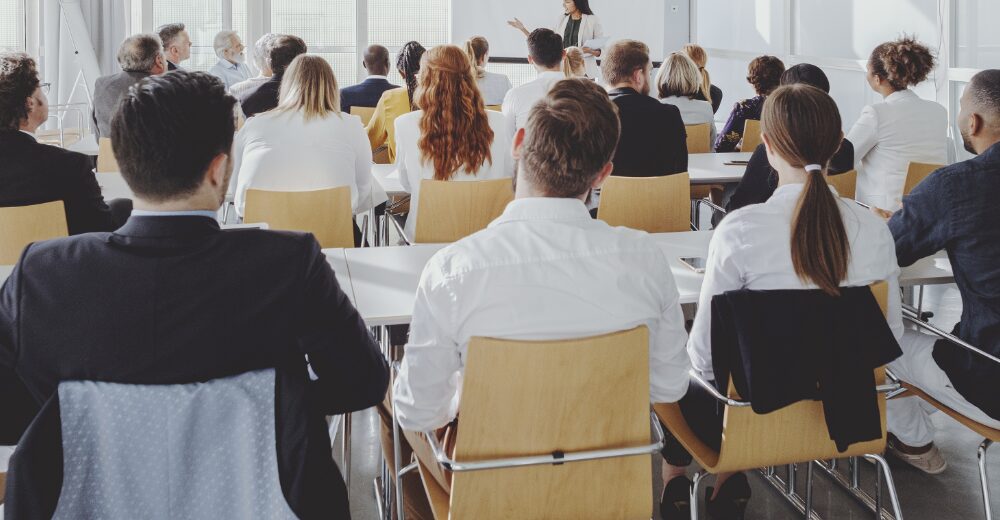 Gruppe von Menschen in einem Seminarraum, Symbol für Veranstaltungen, Events und die Absicherung durch eine Veranstalterhaftpflichtversicherung.
