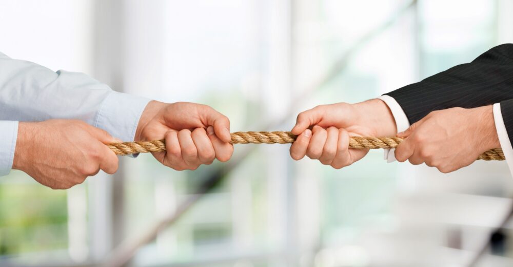 Mehrere Hände ziehen an einem Seil – Symbolbild für Vermögensschaden-Rechtsschutz und wirtschaftliche Streitfälle.