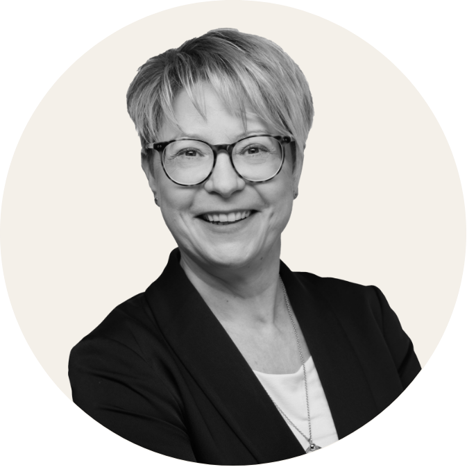 Porträt eines freundlich lächelnden Mannes im Anzug vor hellem, neutralem Hintergrund, schwarz-weiß.