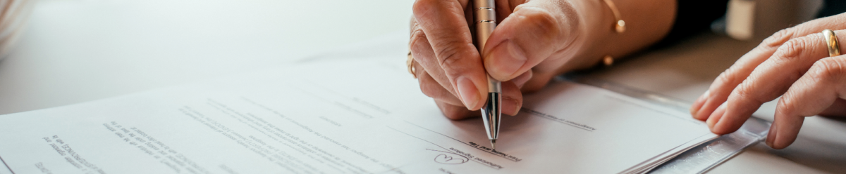 Hand unterzeichnet Finanzierungsvertrag im Büro – Detailaufnahme einer Vertragsunterschrift im Unternehmenskontext