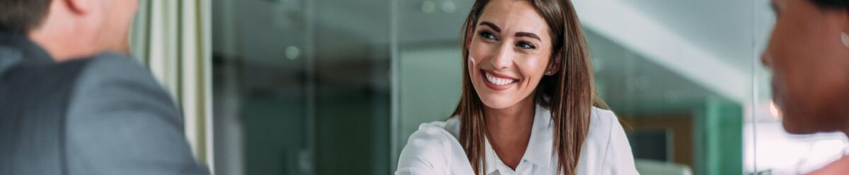 Geschäftsfrau schüttelt Kunden im Büro die Hand während eines Beratungsgesprächs zur Finanzkommunikation