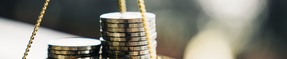 Waage mit gestapelten Münzen als Symbol für faire und ausgewogene Vergütung.