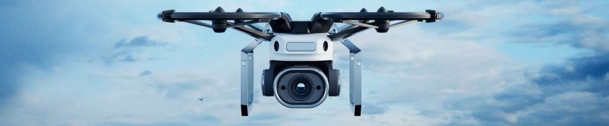 A modern white drone with four black rotors hovers facing the camera against a clear blue sky dotted with white clouds. The compact drone is equipped with a high-resolution digital camera mounted centrally on its underside and optimized for professional aerial photography. The device features the typical symmetrical design of modern multimedia drones and symbolizes advanced technology for photography, videography, and aerial photography.
